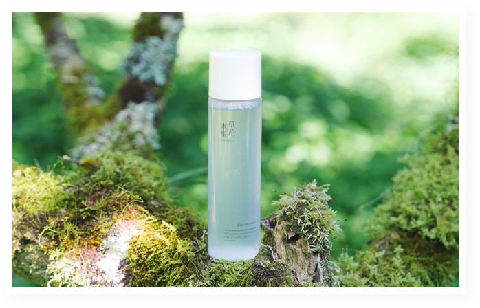 木の上に置かれた草花木果エッセンスローション